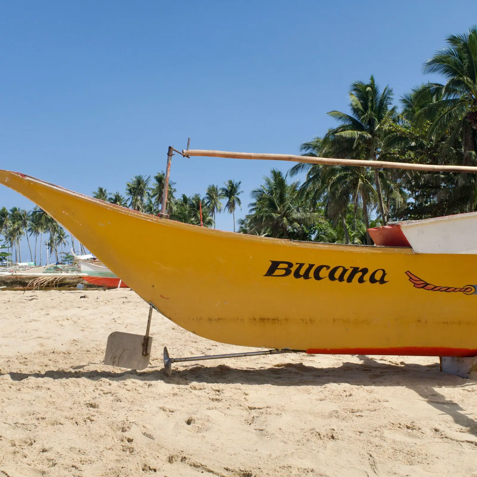 Yellow jukung outrigger boat on the sand