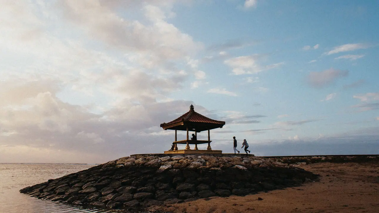 Small Balinese pavilion on a stone breakwater by the sea