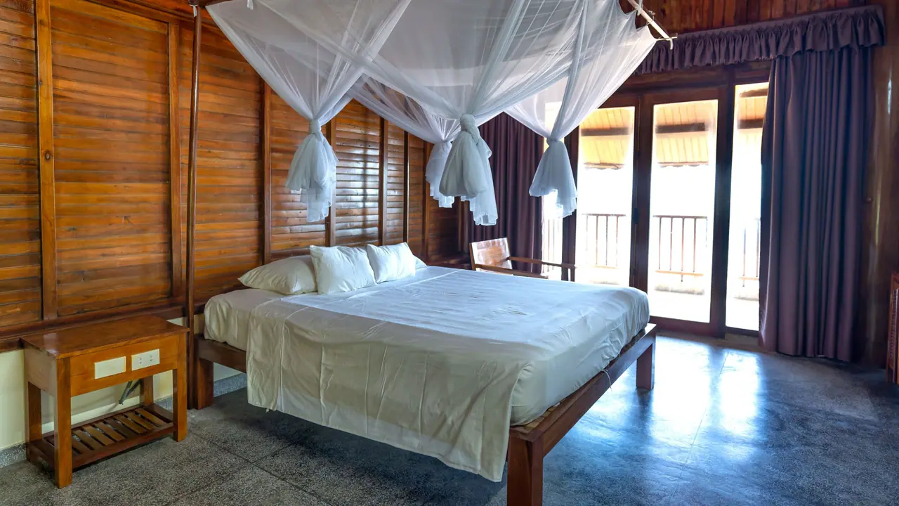 Bedroom with timber walls and a canopy bed