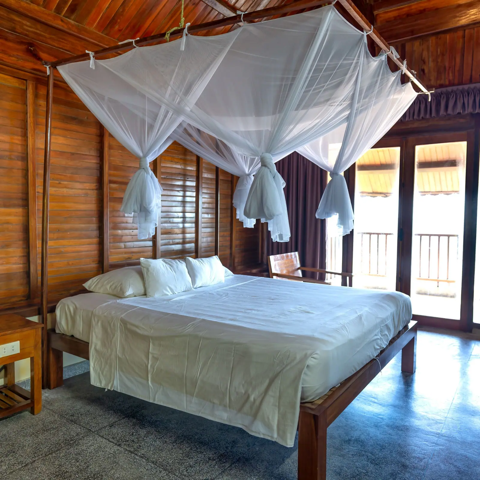 Canopy bed in a room with timber walls