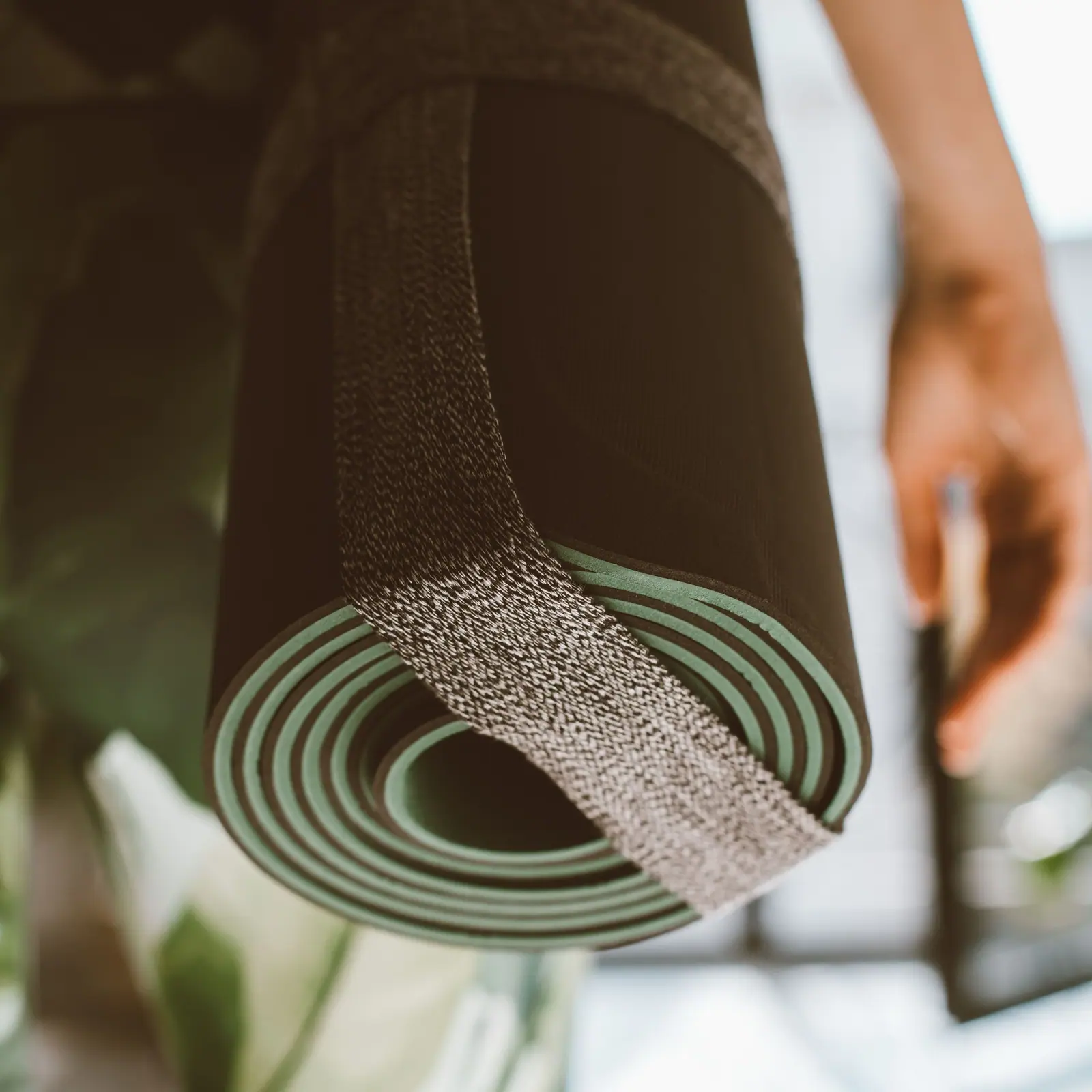Rolled yoga mat held outdoors